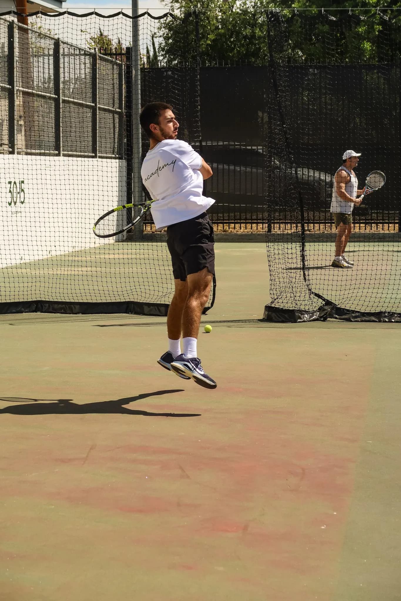 Teen tennis player practicing a forehand on an outdoor court at 30-15 Tennis Academy.